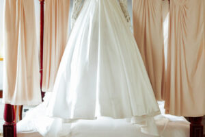 Gorgeous wedding dress and beige gowns for bridesmaids hang over